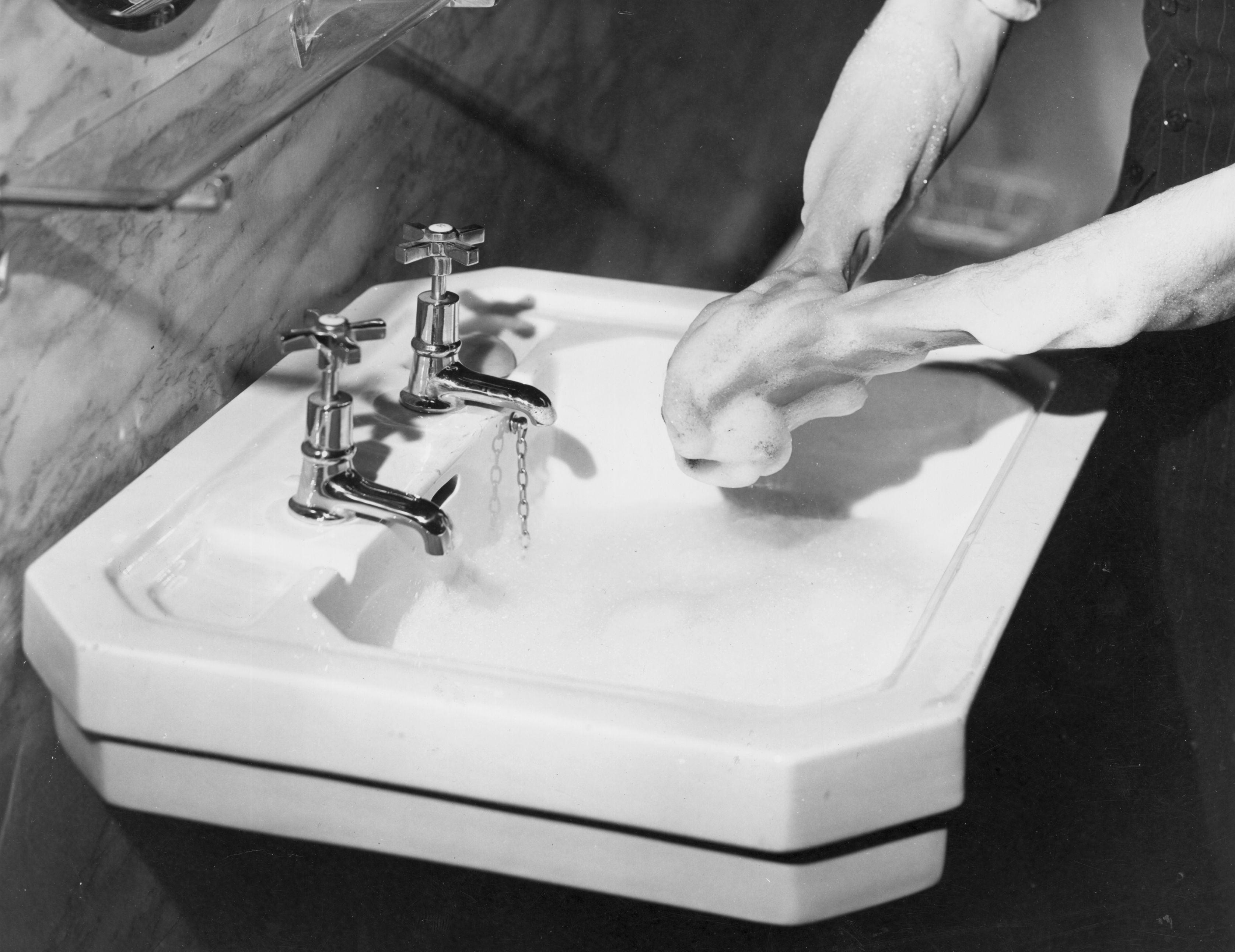 Washing hands in a sink in 1937
